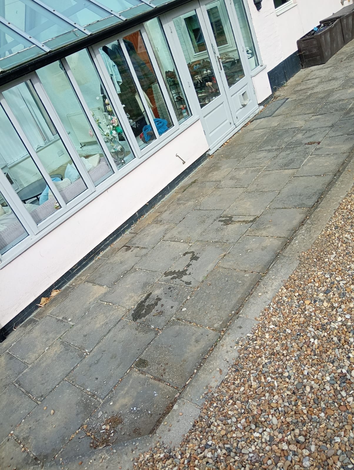The same conservatory path swept clean, paving slabs and gravel border clear